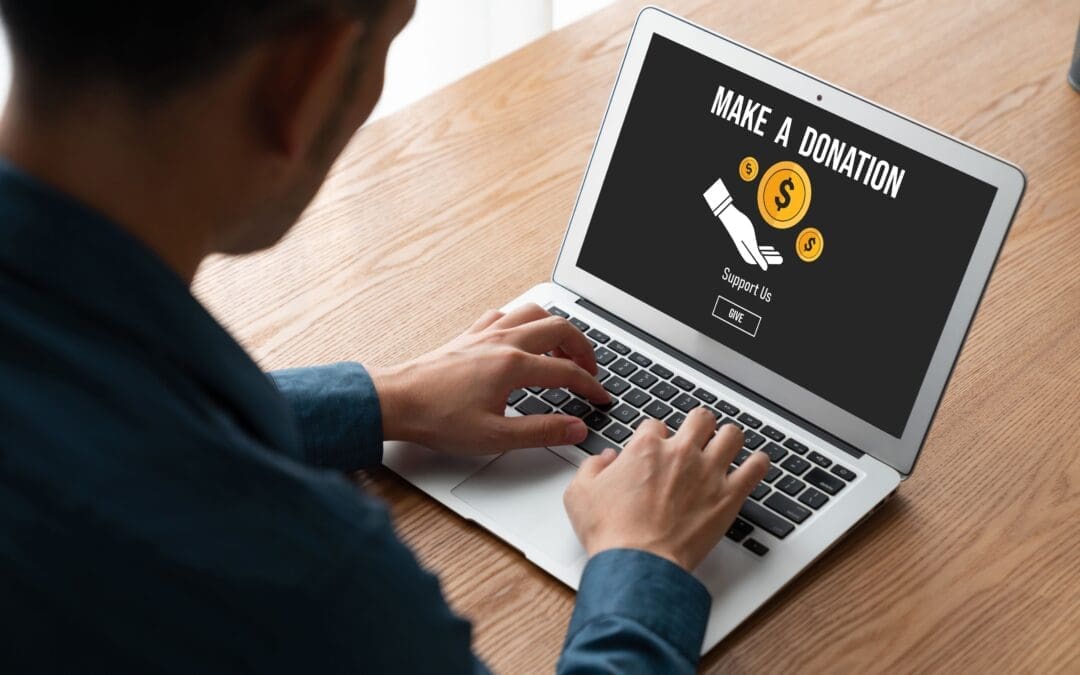 A man typing on a computer to access an Online donation platform