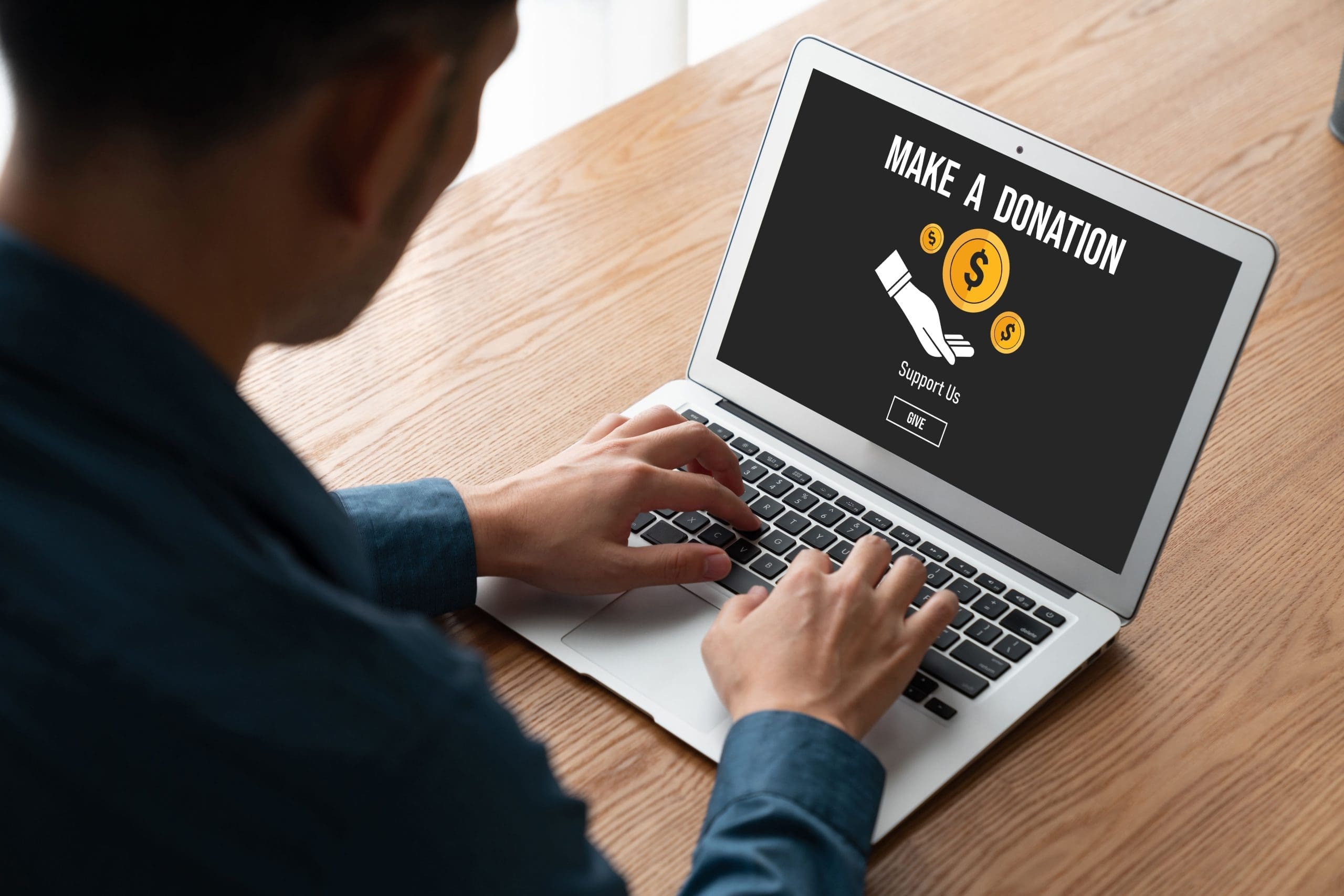 Beautiful happy girl in Santa Claus hat showing gift box A man typing on a computer to access an Online donation platform
