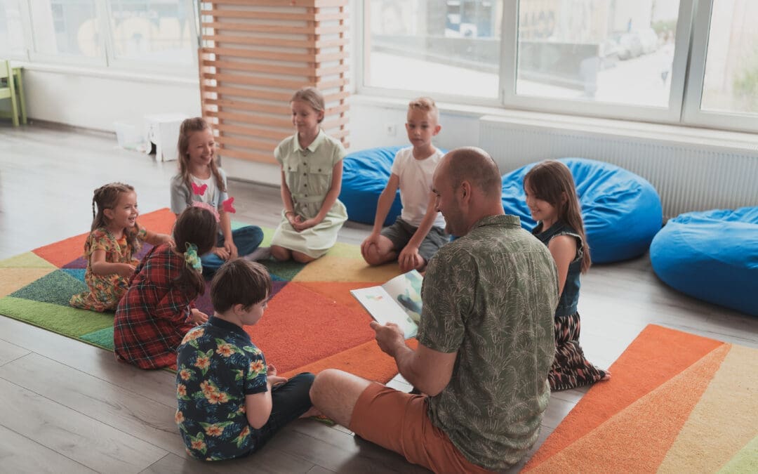 Several kids on a sensory mat with a teacher reading to them.